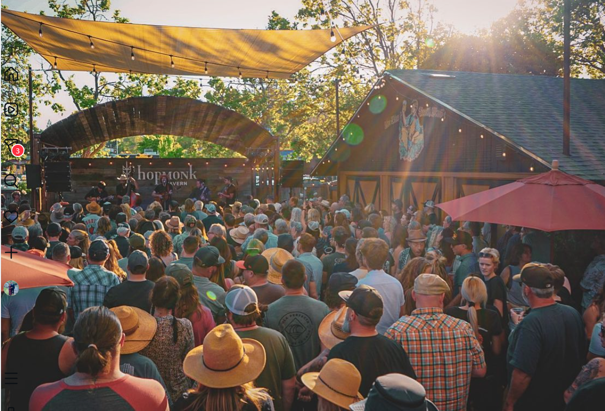 A past outdoor concert in HopMonk Sebastopol’s beer garden beneath trees and string lights